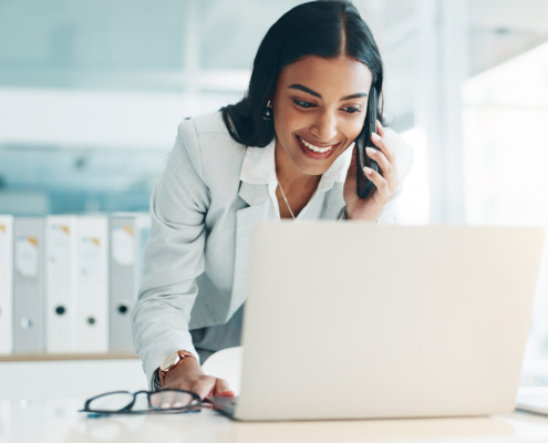 Front view of young woman on laptop computer smiling