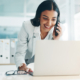 Front view of young woman on laptop computer smiling