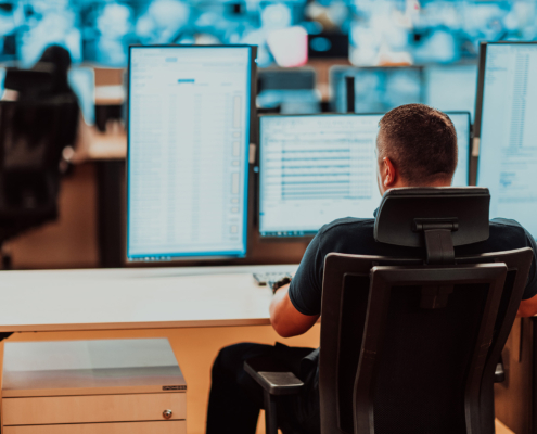 Male security operator working in a data system control room